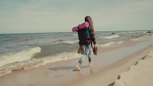 Hiker walks along a wild beach