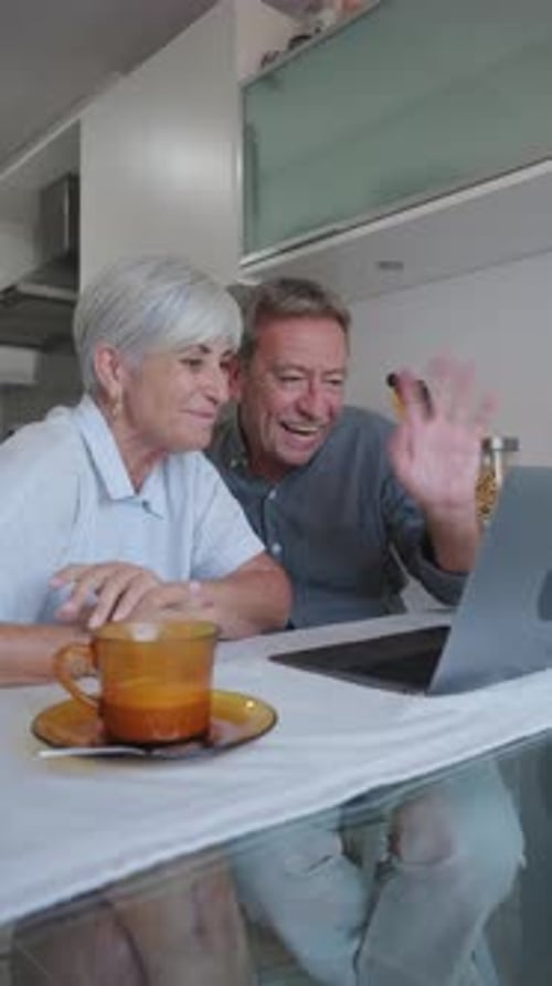 Senior Couple Video Chatting on Laptop in Kitchen