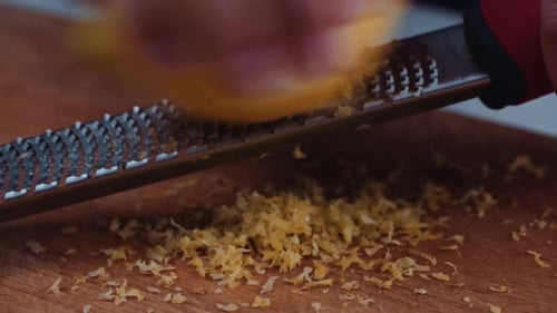 Person Zesting A Lemon - Scraping The Outer Colored Part Of The Peel Of A Lemon. - close up shot