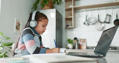 Online class, laptop and child with headphones in kitchen, learning and education with home school