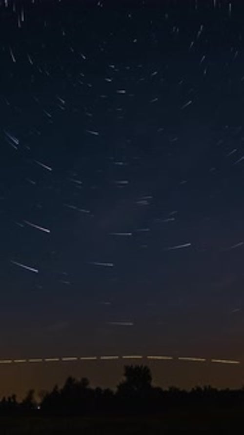 Sternenspuren am Nachthimmel mit Kometenspuren über dem Horizont