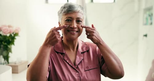 Woman Applies Cream To Face in Bathroom