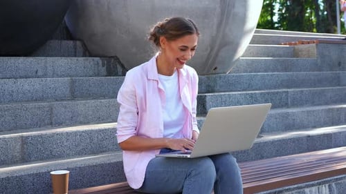 Businesswoman Having Video Call on Laptop on Steps in Park