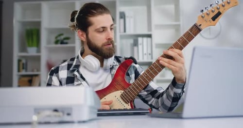 Man Plays Electric Guitar at Home Studio