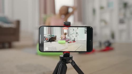 Tutorial de grabación de yoga para mujer con teléfono inteligente en un estudio doméstico, transmisión de acondicionamiento físico femenino