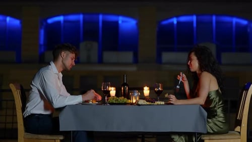 Couple Enjoying Romantic Dinner at Night Restaurant