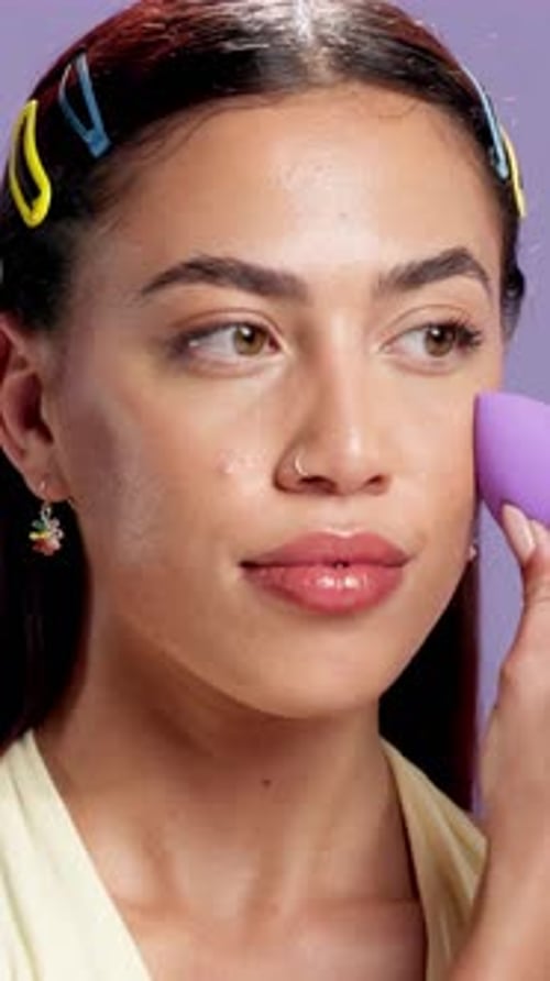 Blush, makeup and sponge with face of woman in studio for shine, foundation application