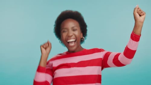 Fist pump, excited and face of black woman in studio with good news, winning