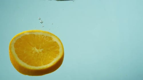 Orange Half Plunges Into Refreshing Water