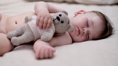 Sleeping Infant Embraces Teddy Bear