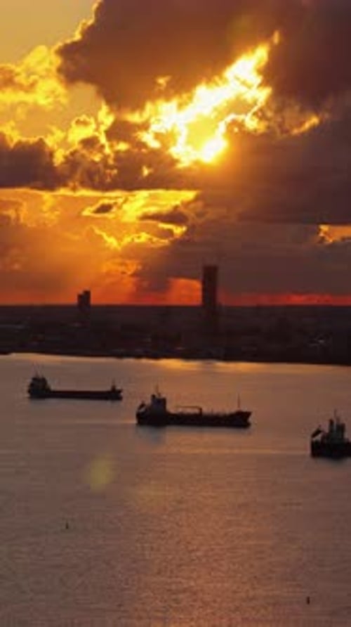 Aerial drone view of ships anchored offshore near Limassol during sunset, with warm light reflecting