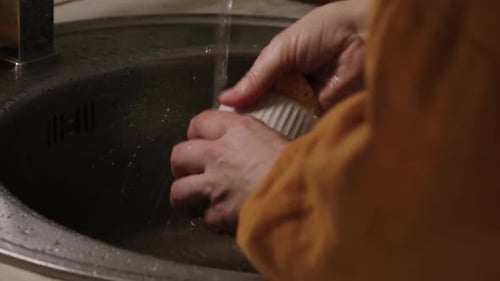 Adult Washing White Coffee Cup in Kitchen Sink
