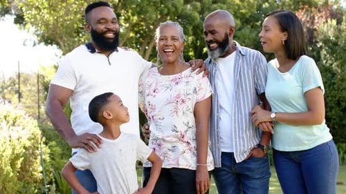 Smiling african american family posing together outdoors, enjoying quality time in garden