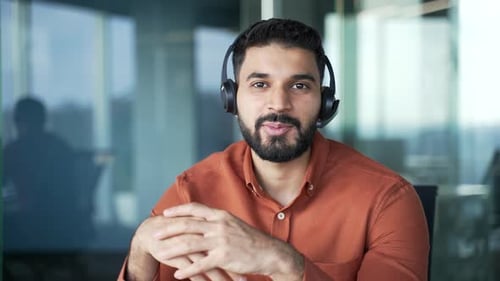 Webcam view. Confident businessman in wireless headset talking on a video call looking at camera
