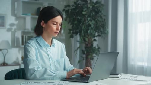 Woman Working on Laptop in Home Office