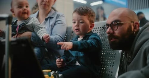Family with Children Waiting for Airplane Flight in Departure Lounge