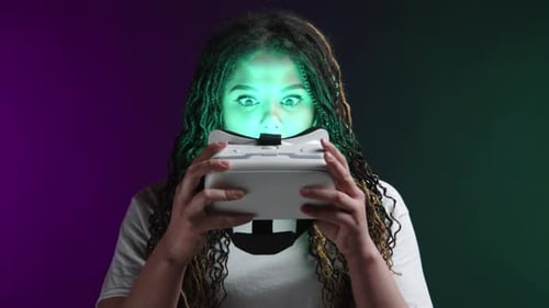 Woman Putting on Virtual Reality Headset in Studio