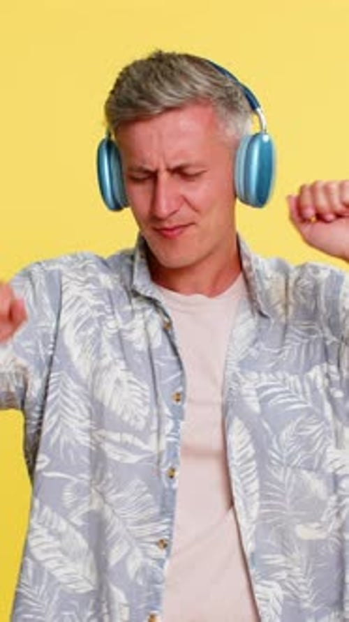 Man with Headphones Joyfully Dancing to Music