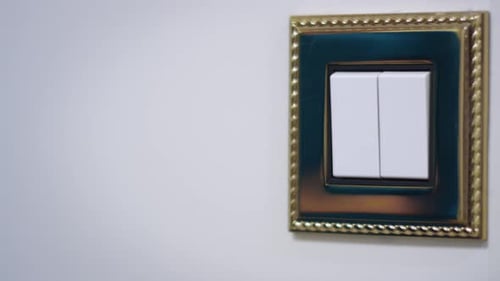 Mão de mulher apagando a luz na parede branca em um quarto aconchegante durante a noite