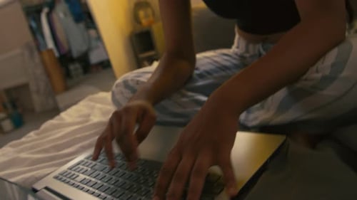 Young Adult Working on Laptop in Bed