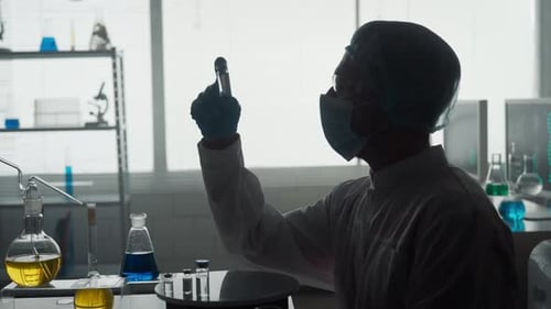 Medical Researcher Examining Vial in Bright Lab