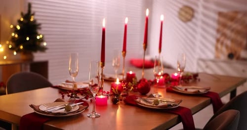Christmas Dinner Table Setting with Candles and Decorations