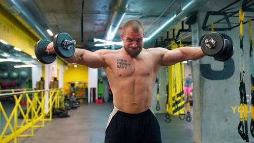 Muscular Man Lifting Weights in a Modern Gym