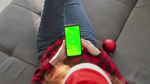 Woman Wearing Santa Hat with Green Screen Phone