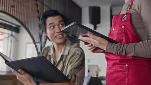 Waitress with Tablet PC Taking Male Clients Order in Cafe