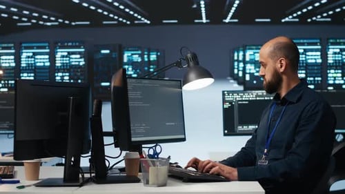 Man Typing at Computer in Brightly Lit Office