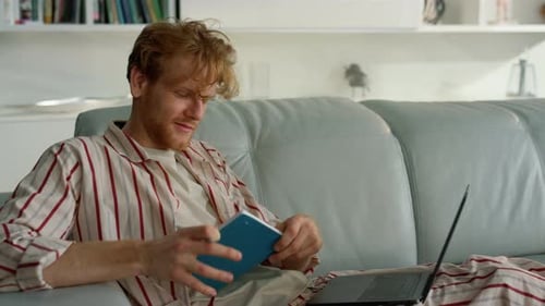 Smiling Guy Elearning Home on Weekend Closeup. Ginger Student Work Making Notes