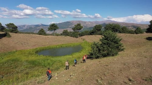Group Of People Trekking By The Lake