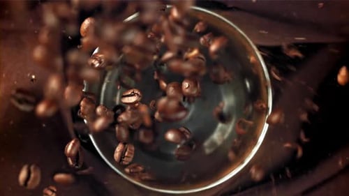 Roasted Coffee Beans Falling into Silver Grinder