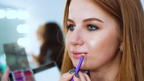 Woman Applying Lipstick with Brush Close Up