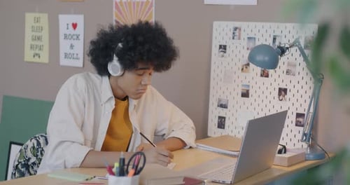 Young Adult Studying with Laptop and Headphones