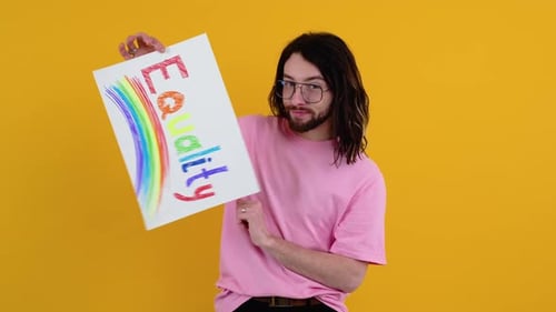 Attractive Bearded Gay Caucasian Man Holding a Protest Sign During a LGBT Pride Parade
