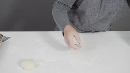 Woman Rolling Dough on White Countertop for Baking