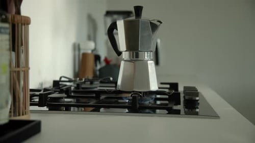 Cafetera Bialetti Moka Express tradicional que prepara café en una estufa de gas por la mañana. Ampliar