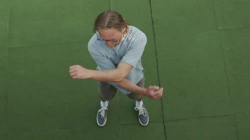 Top View of Mid-Aged Man Doing Warm Up Exercise while Training Outdoors