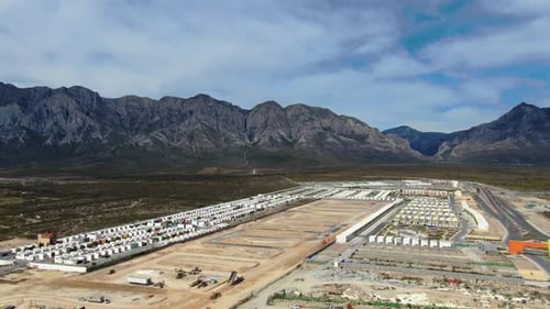 Aerial View of Industrial Construction Site Near Large Mountain Range