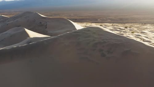 Aerial drone view of spectacular majestic sand piles of Kelso Dunes at sunrise, California