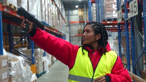 Female Warehouse Worker Scanning Barcodes in Cold Storage