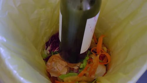 Wine Bottle Dropped Into Food Scraps in Trash