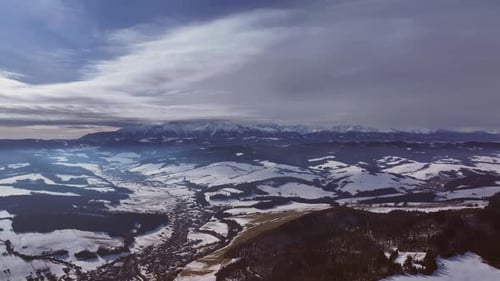 Winter landscape of rolling hills and snow-covered valleys at sunset