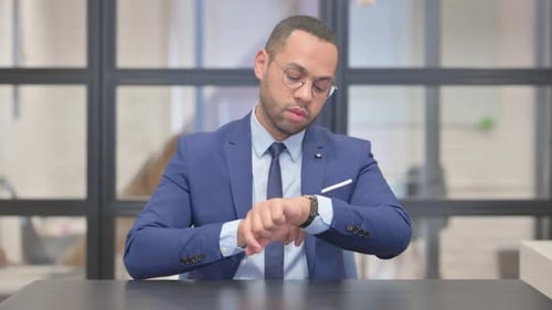 Businessman Waiting and Checking Time at Meeting