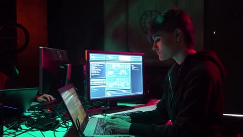 Young Adults Coding in a Dimly Lit Room