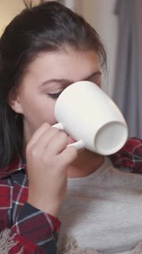 Woman Sipping from a Mug, Smiling