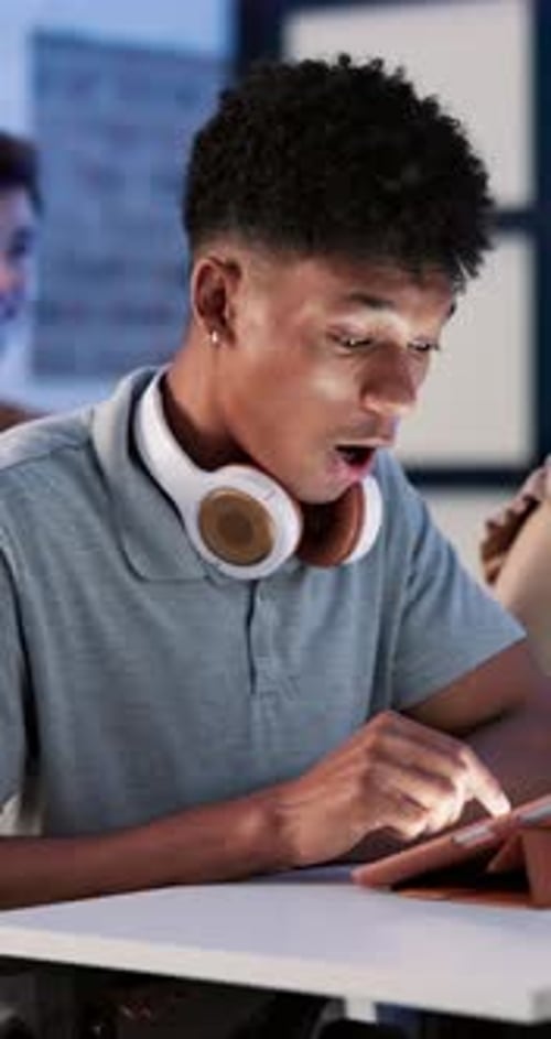 Surprised Young Adult Using Tablet at Desk at Night