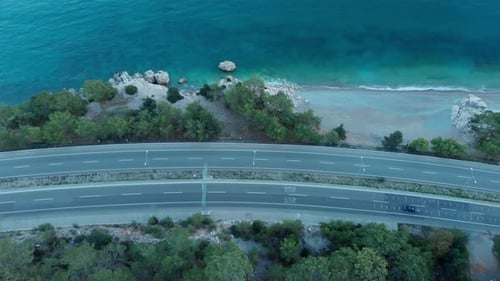 The Camera Flies Over the Road Located on the Seashore in the Evening