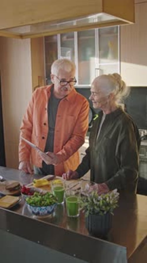Seniors Looking at Tablet in Bright Kitchen